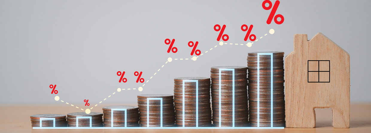 Stijgende stapeltjes munten met een rentepercentage erboven met aan het einde van de stapeltjes een afbeelding van een huis