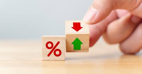 Rente financiële en hypotheekrente concept. Hand flip houten kubus verandering pijl naar beneden naar boven